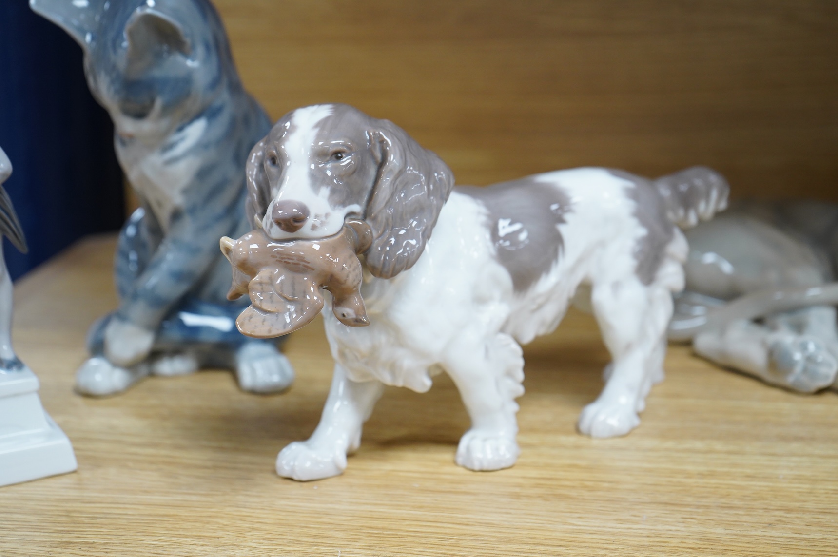 A Royal Copenhagen figure, 'The Sandman', Number 1129, a similar cat, number 340, a B&G spaniel and a Danish lion, tallest 18.5cm